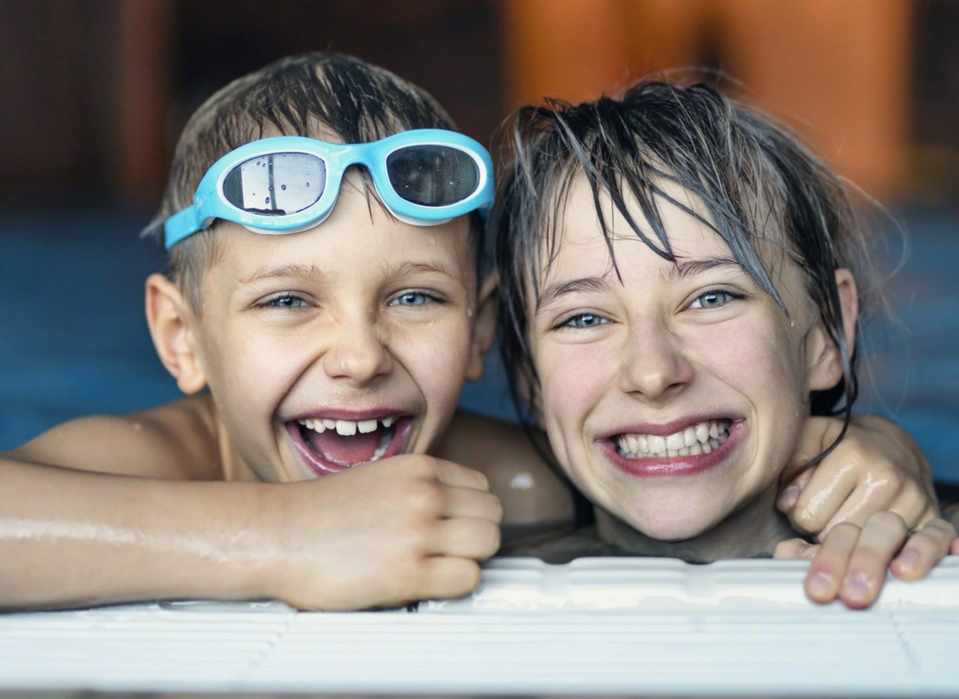 dwoje dzieci nad brzegiem basenu